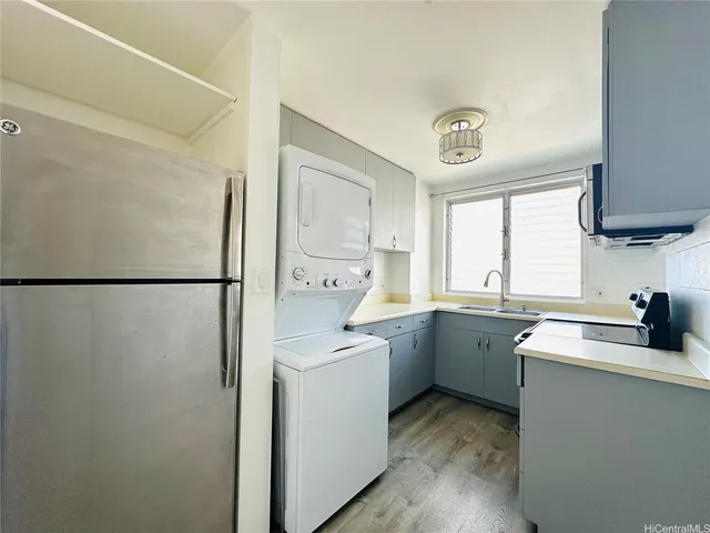 a kitchen with a sink a refrigerator and cabinets