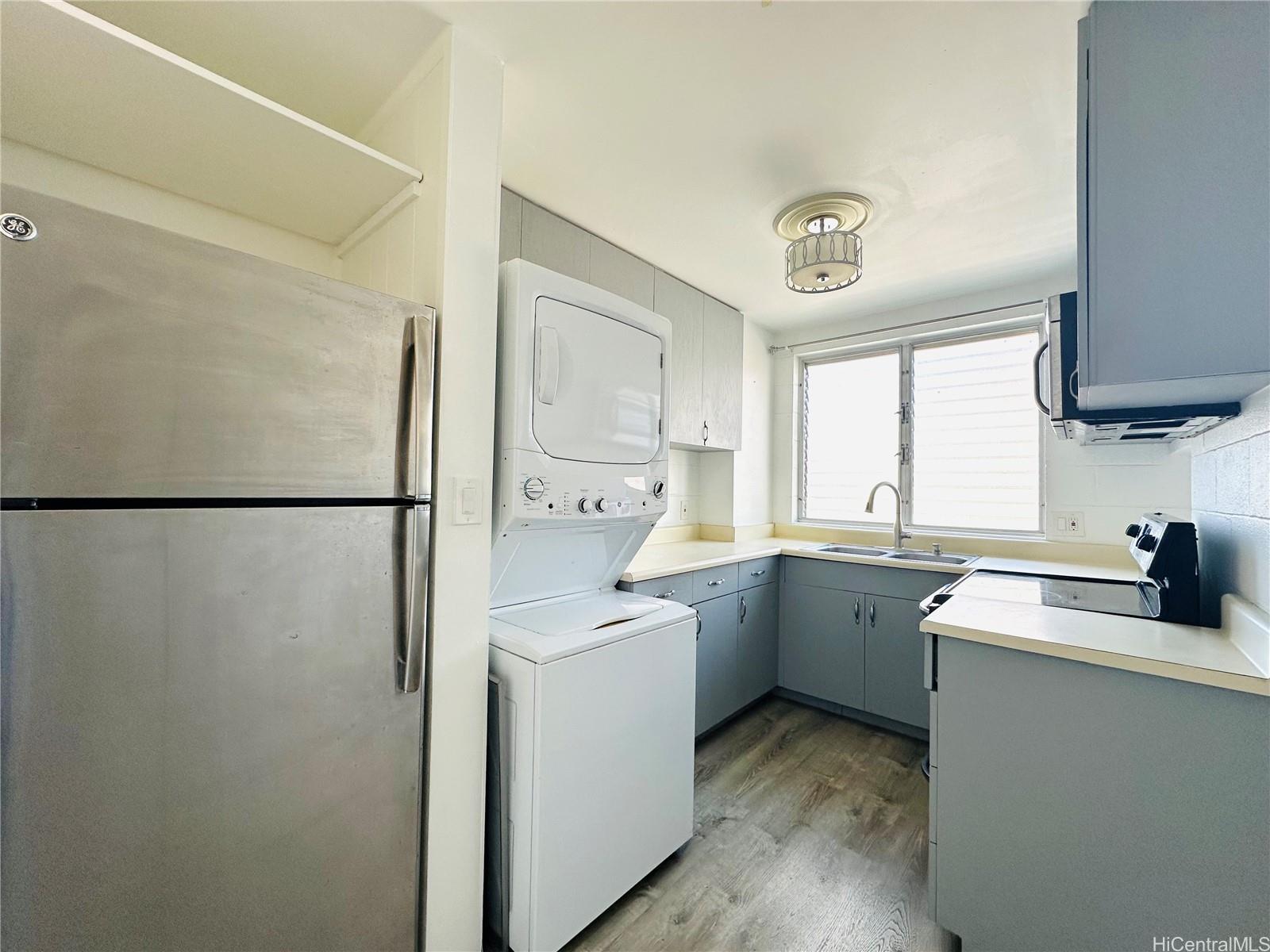 a kitchen with a sink a refrigerator and cabinets