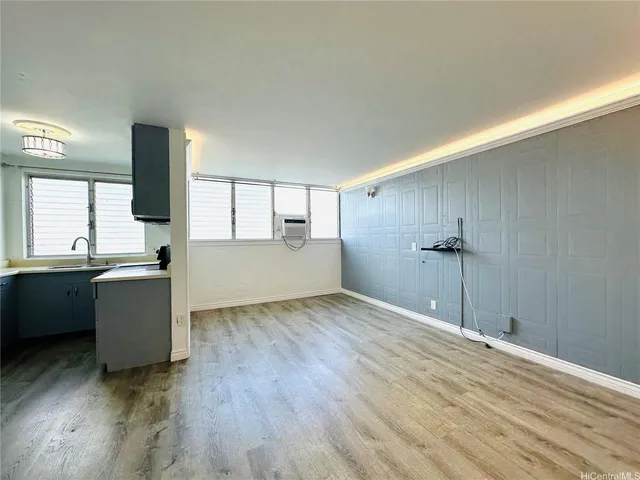 a view of a kitchen with a sink and dishwasher with wooden floor