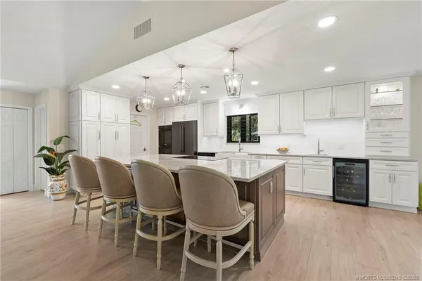 a large kitchen with kitchen island a dining table and chairs