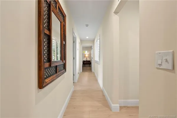 a view of a hallway with wooden floor and staircase