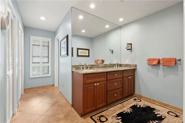 a spacious bathroom with a granite countertop sink a mirror and a shower