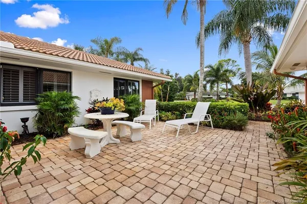 a view of a patio with plants and chairs