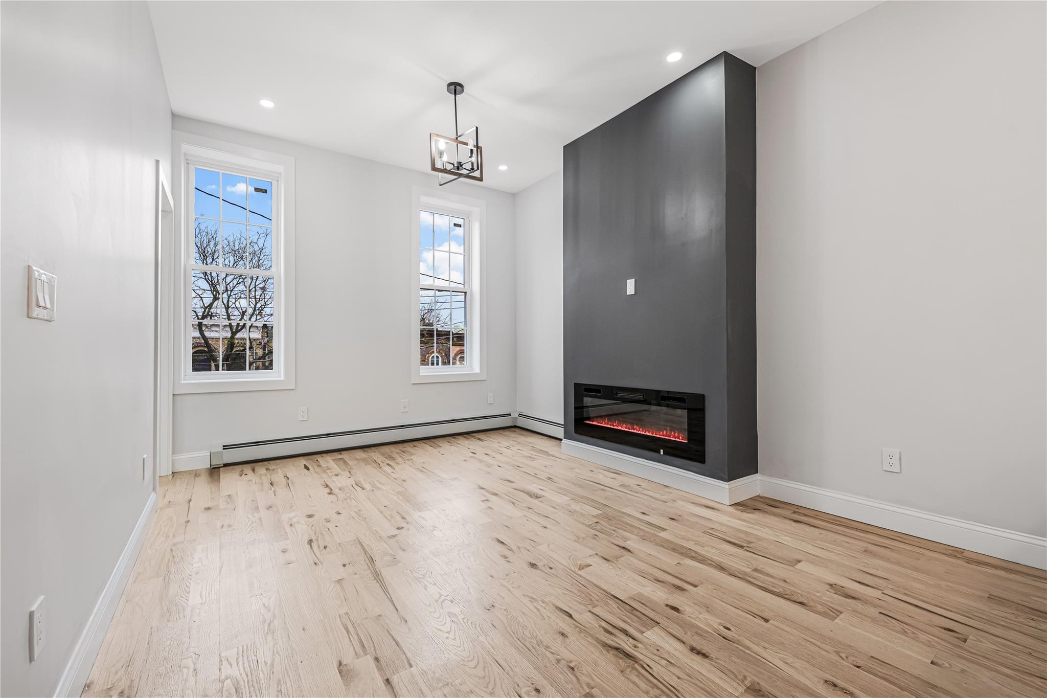 164 Atkins Avenue, Unit 1 Brooklyn, NY 11208 - Photo 16 of 18 a view of an empty room with wooden floor and a window