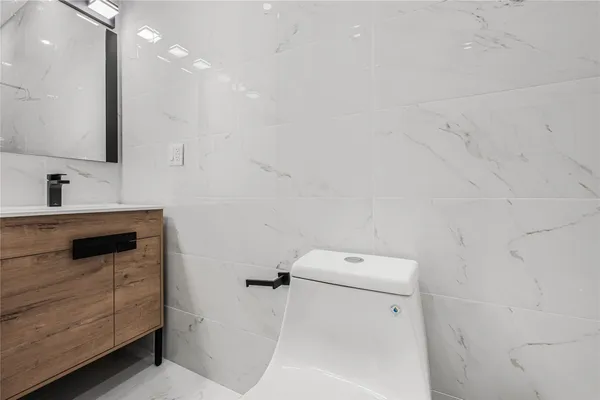 a bathroom with a sink vanity and toilet