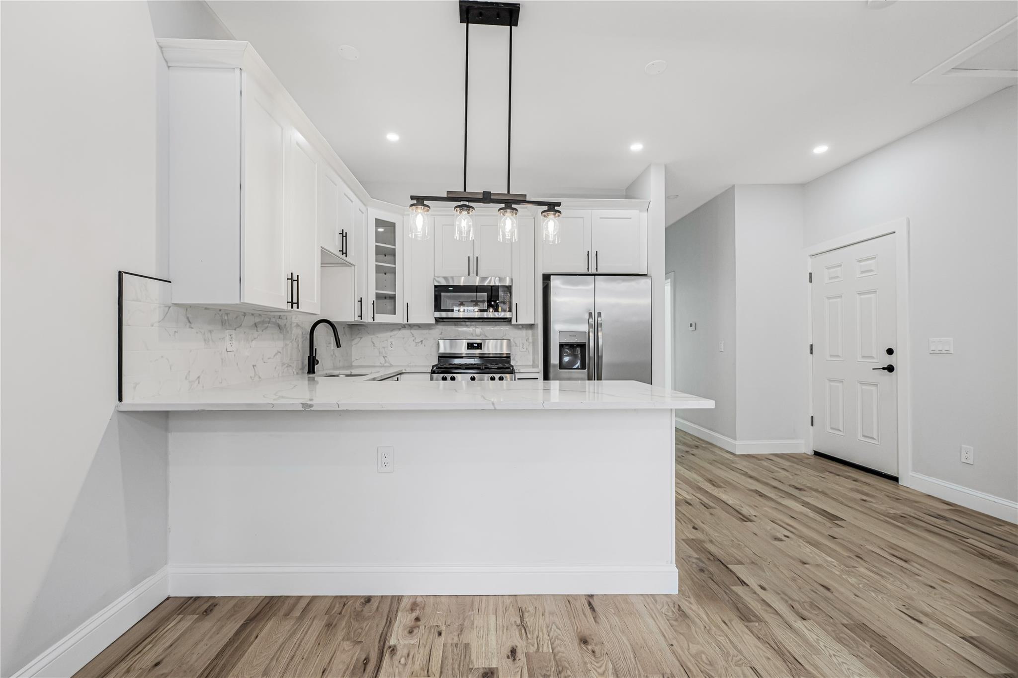 164 Atkins Avenue, Unit 1 Brooklyn, NY 11208 - Photo 8 of 18 a view of kitchen with stainless steel appliances granite countertop a stove a sink and a refrigerator with wooden floors