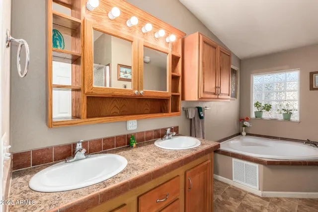 a bathroom with a granite countertop sink and a window