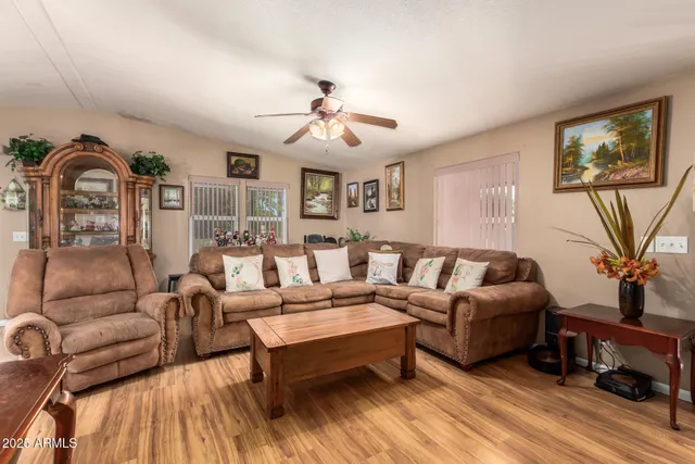 a living room with furniture a ceiling fan and a window