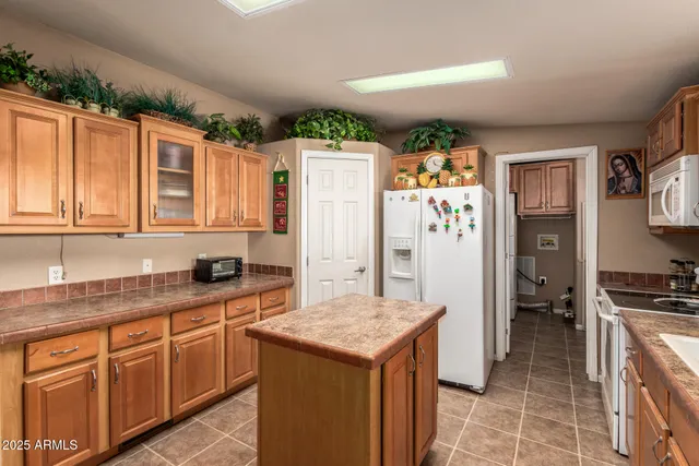 a kitchen with stainless steel appliances granite countertop a refrigerator a stove and a sink