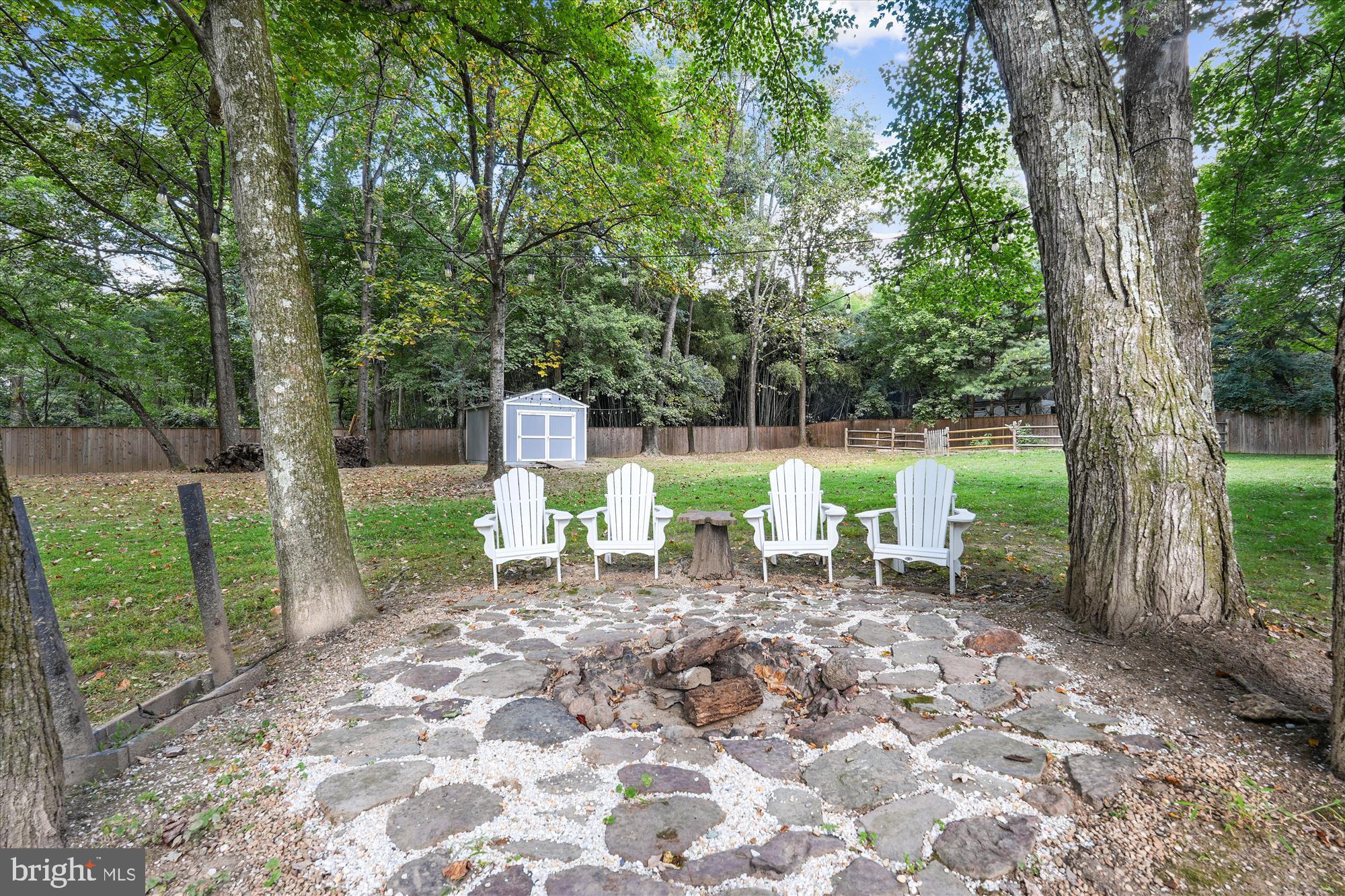 15418 Peach Orchard Road Silver Spring, MD 20905 - Photo 11 of 47 Cozy fire pit nestled among lush trees.
