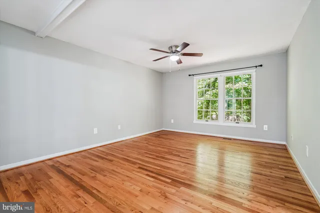 wooden floor in an empty room with a window