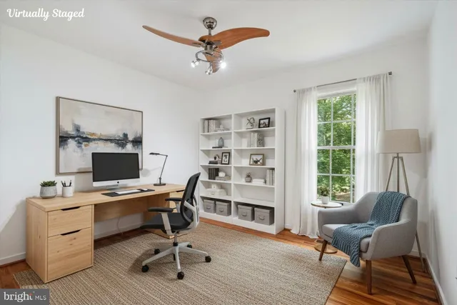 a view of a workspace with furniture and a window