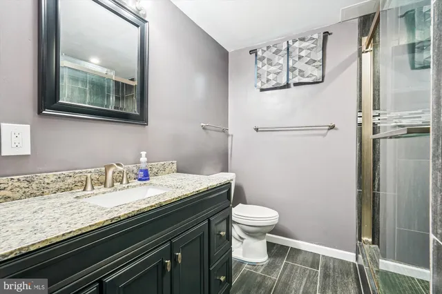 a bathroom with a granite countertop toilet sink and a mirror