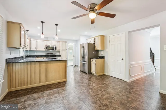 a view of kitchen with refrigerator stove microwave and cabinets