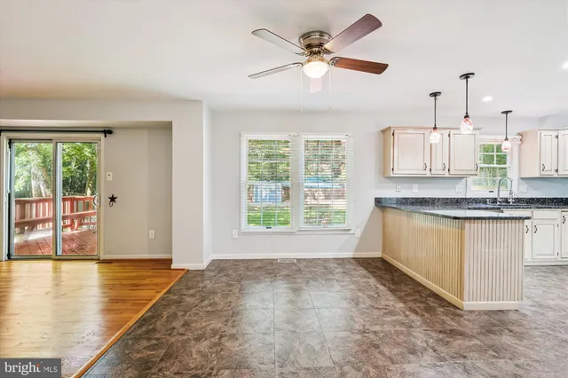 a view of a kitchen with wooden floor and a window