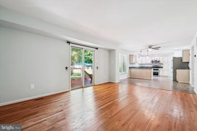 a view of a kitchen with wooden floor electronic appliances and window