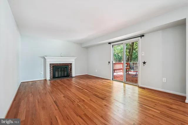 a view of empty room with wooden floor and fireplace