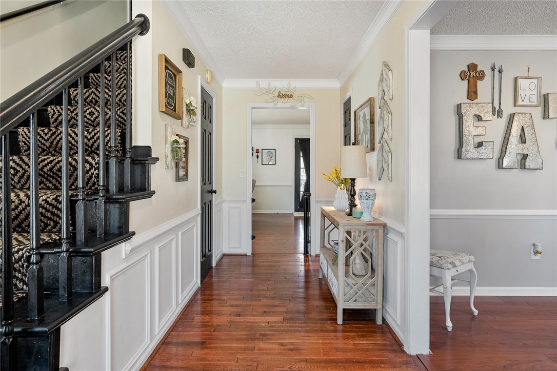 112 C-10-220 Anderson, SC 29621 - Photo 5 of 45 This inviting hallway features classic wainscoting and warm hardwood floors, leading to a charming entryway.
