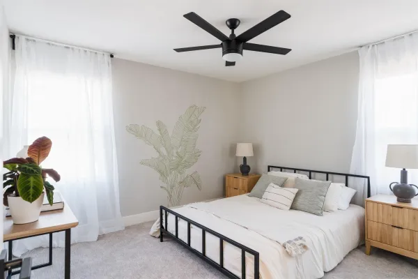a bedroom with a bed and a potted plant