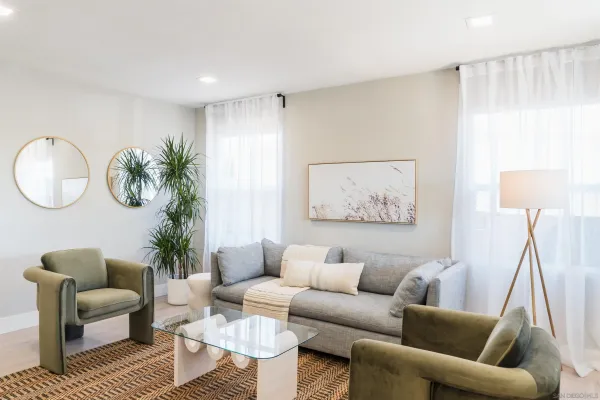 a living room with furniture a mirror and a window