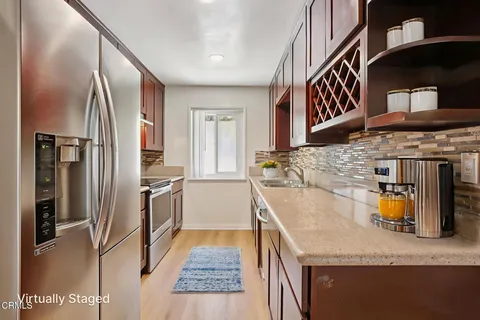 a kitchen with stainless steel appliances granite countertop a sink and a refrigerator
