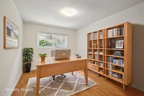 a view of a workspace with furniture and bookshelf