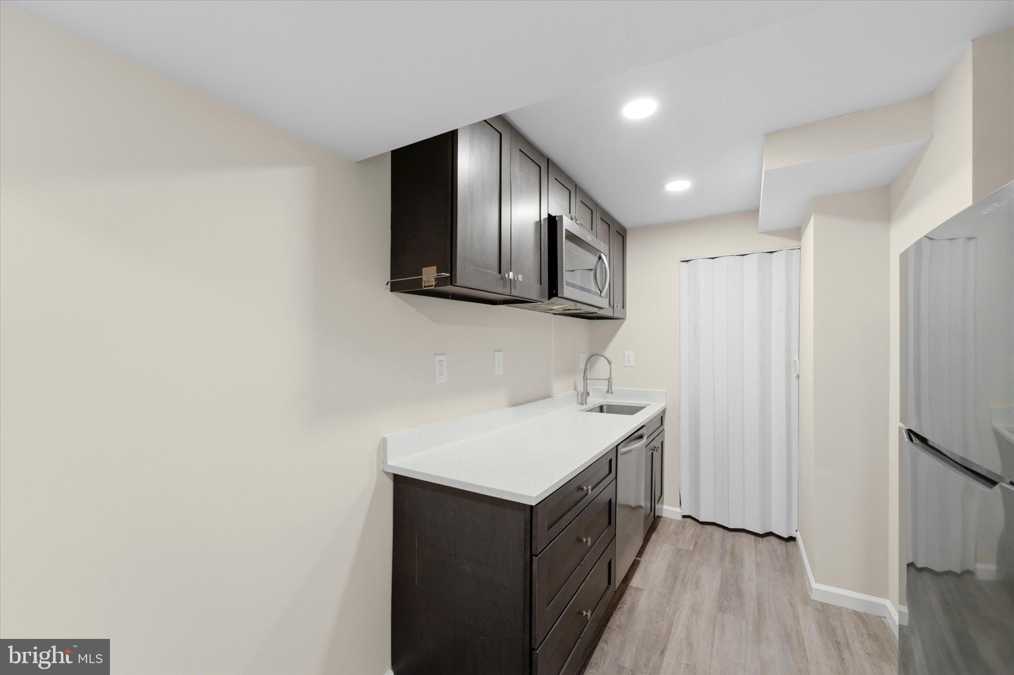 13511 Chevy Chase Court Chantilly, VA 20151 - Photo 36 of 57 a kitchen with a sink cabinets and wooden floor