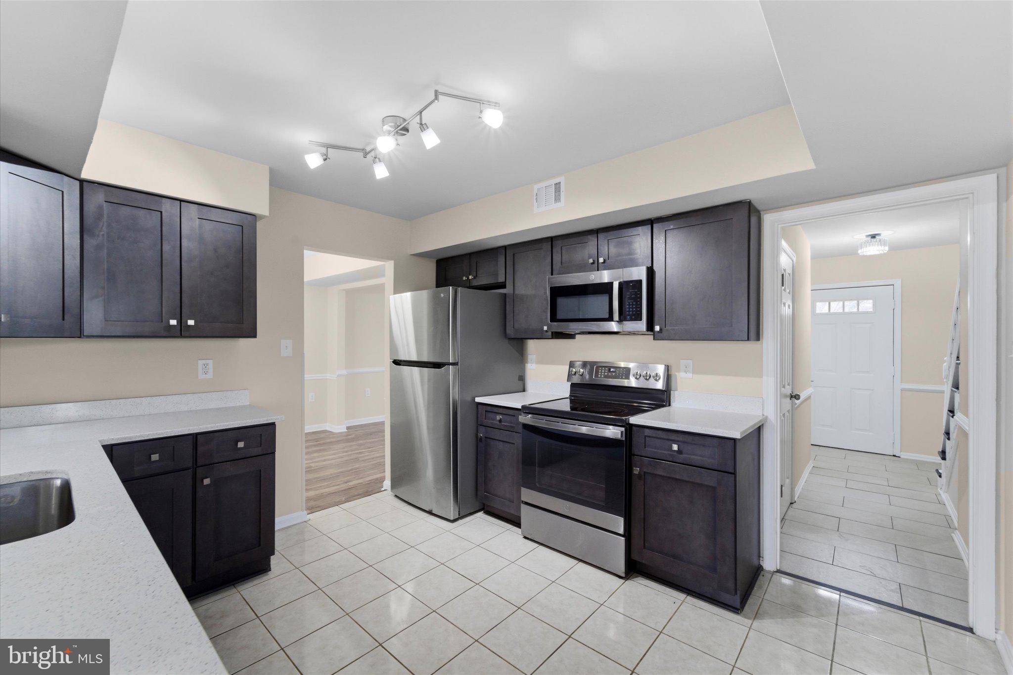 13511 Chevy Chase Court Chantilly, VA 20151 - Photo 5 of 57 a kitchen with granite countertop a refrigerator and a stove top oven