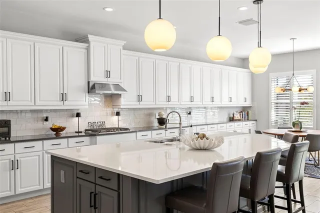 a kitchen with granite countertop a sink stainless steel appliances and cabinets