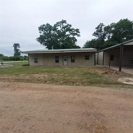 a front view of house with yard and trees around