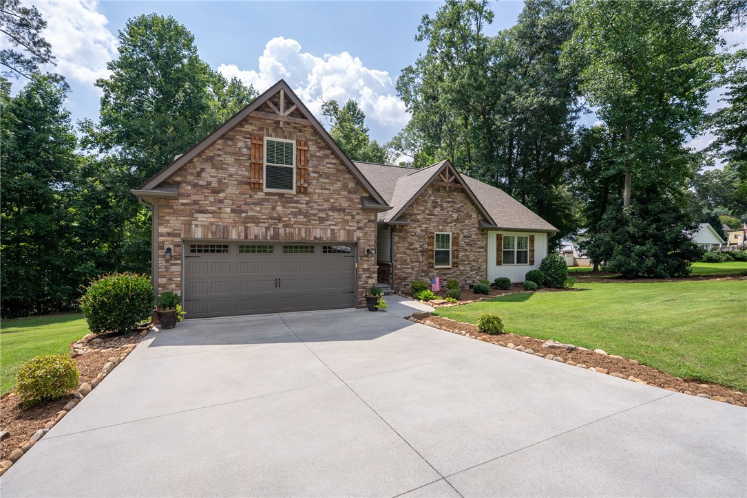 201 Hearthstone Drive Anderson, SC 29621 - Photo 3 of 49 A traditional stone facade home welcomes with a concrete driveway and lush, well-maintained lawn.