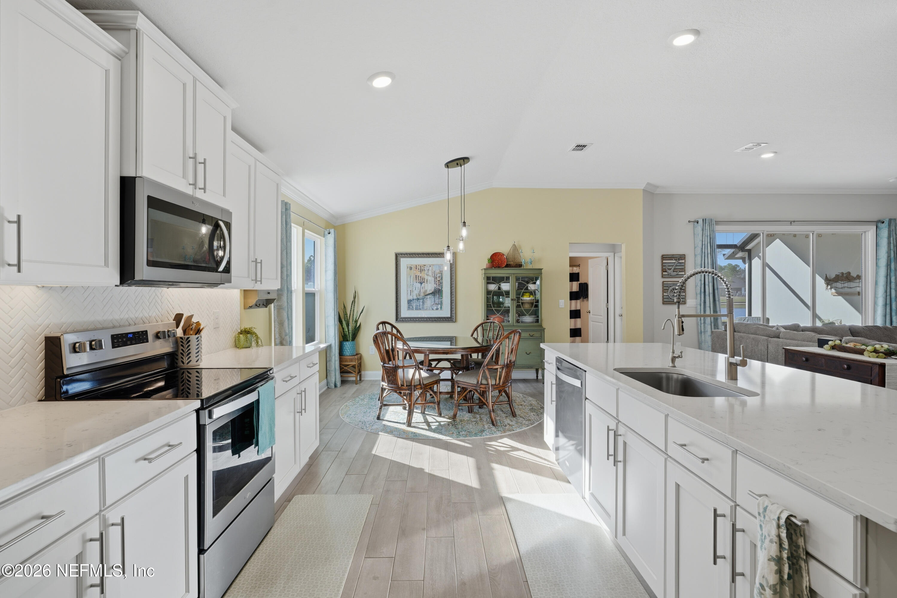 71 Gypsum Pl Street St. Augustine, FL 32086 - Photo 11 of 42 a kitchen with stainless steel appliances a stove a sink a oven a dining table and chairs