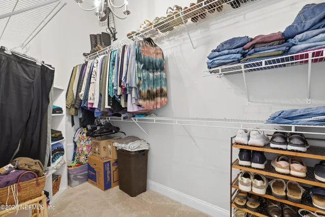 a view of walk in closet with clothes and shoes