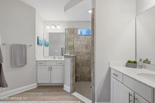 a spacious bathroom with a shower sink and mirror