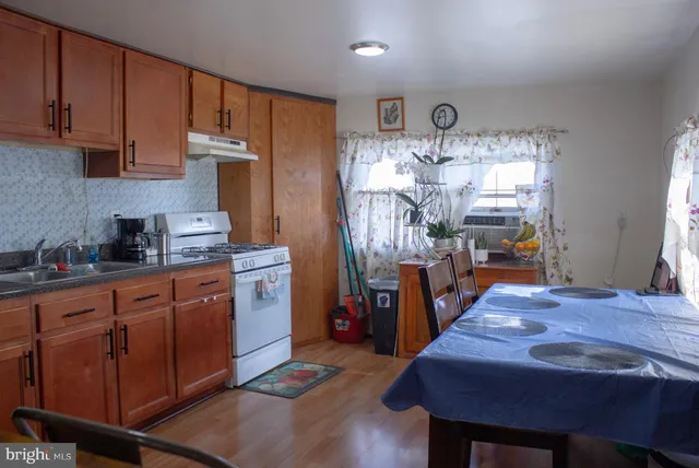 a kitchen with cabinets wooden floor and stainless steel appliances