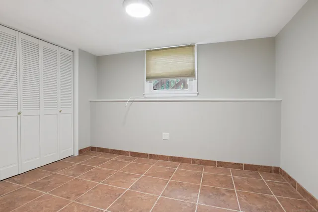 a view of an empty room with window and closet area