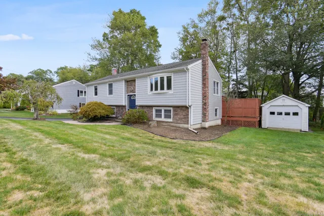 a view of a house with a big yard plants and large trees
