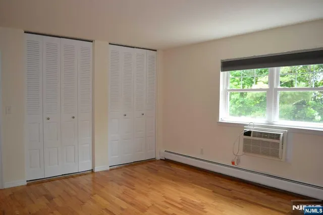 a view of a kitchen with wooden floor and a window