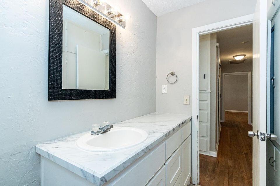 4212 42nd Street Lubbock, TX 79413 - Photo 15 of 18 a bathroom with a sink and a mirror