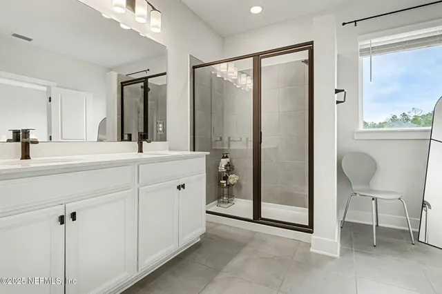 a bathroom with a double vanity sink mirror and shower