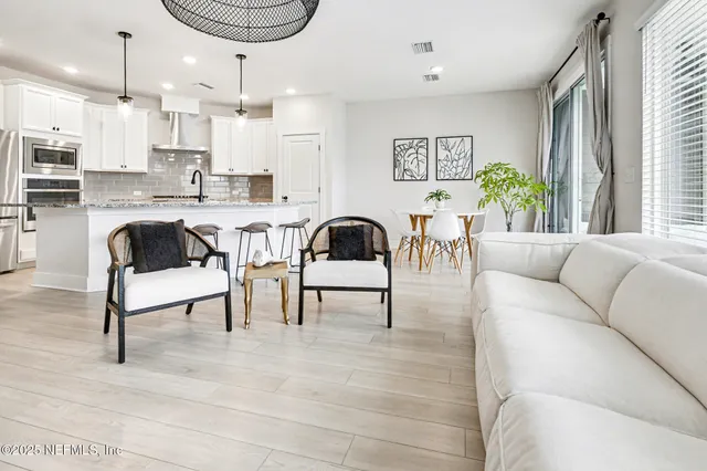 a living room with furniture a rug and a kitchen