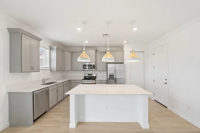 a kitchen with stainless steel appliances a sink stove and cabinets