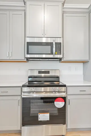 a view of kitchen with stainless steel appliances refrigerator stove microwave and cabinets