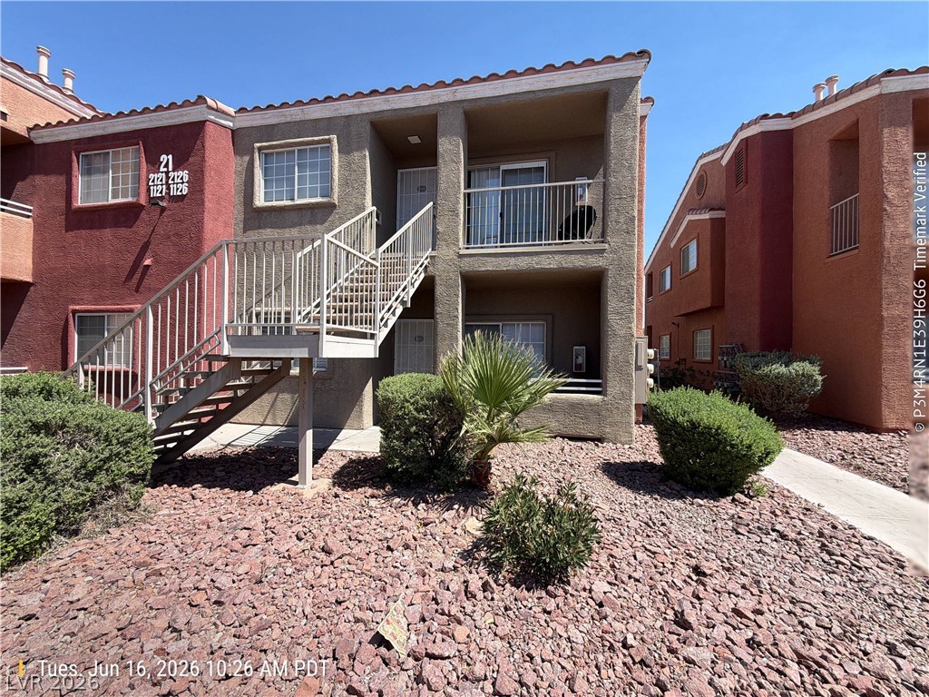 4730 East Craig Road, Unit 1124 Las Vegas, NV 89115 - Photo 2 of 22 Multi-level living spaces offer private balconies, complemented by manicured shrubbery and a clean walkway.