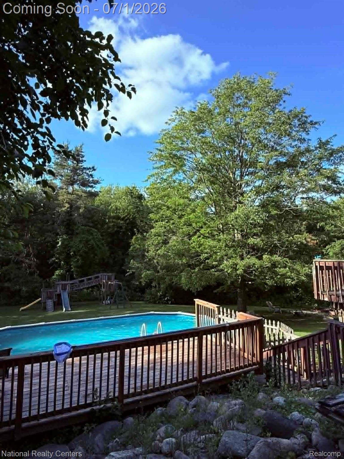 1330 Brauer Road Oxford, MI 48371 - Photo 22 of 54 Expansive outdoor area featuring a swimming pool, wood-plank decking with railings, and a surrounding lawn