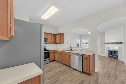 a kitchen with stainless steel appliances granite countertop a refrigerator stove and sink
