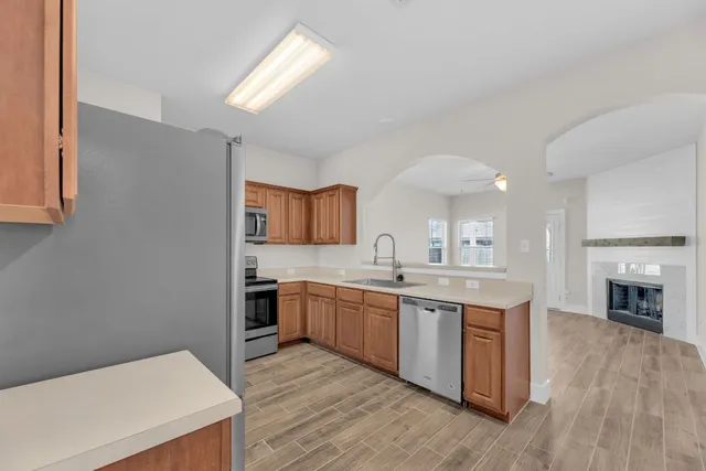 a kitchen with stainless steel appliances granite countertop a refrigerator stove and sink