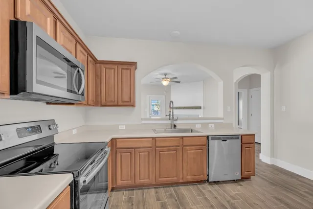 a kitchen with stainless steel appliances granite countertop a refrigerator stove and sink