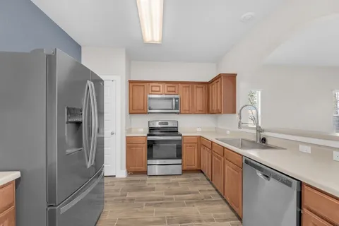 a kitchen with stainless steel appliances granite countertop a sink and stove top oven