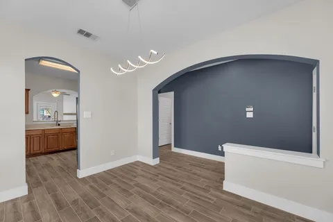 a view of a room with a window and a chandelier fan
